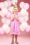 Balloons, lollipop and portrait of girl in studio for birthday party, celebration and special day. Happy, excited and young cute child smile with candy, sweet treats and dessert on pink background