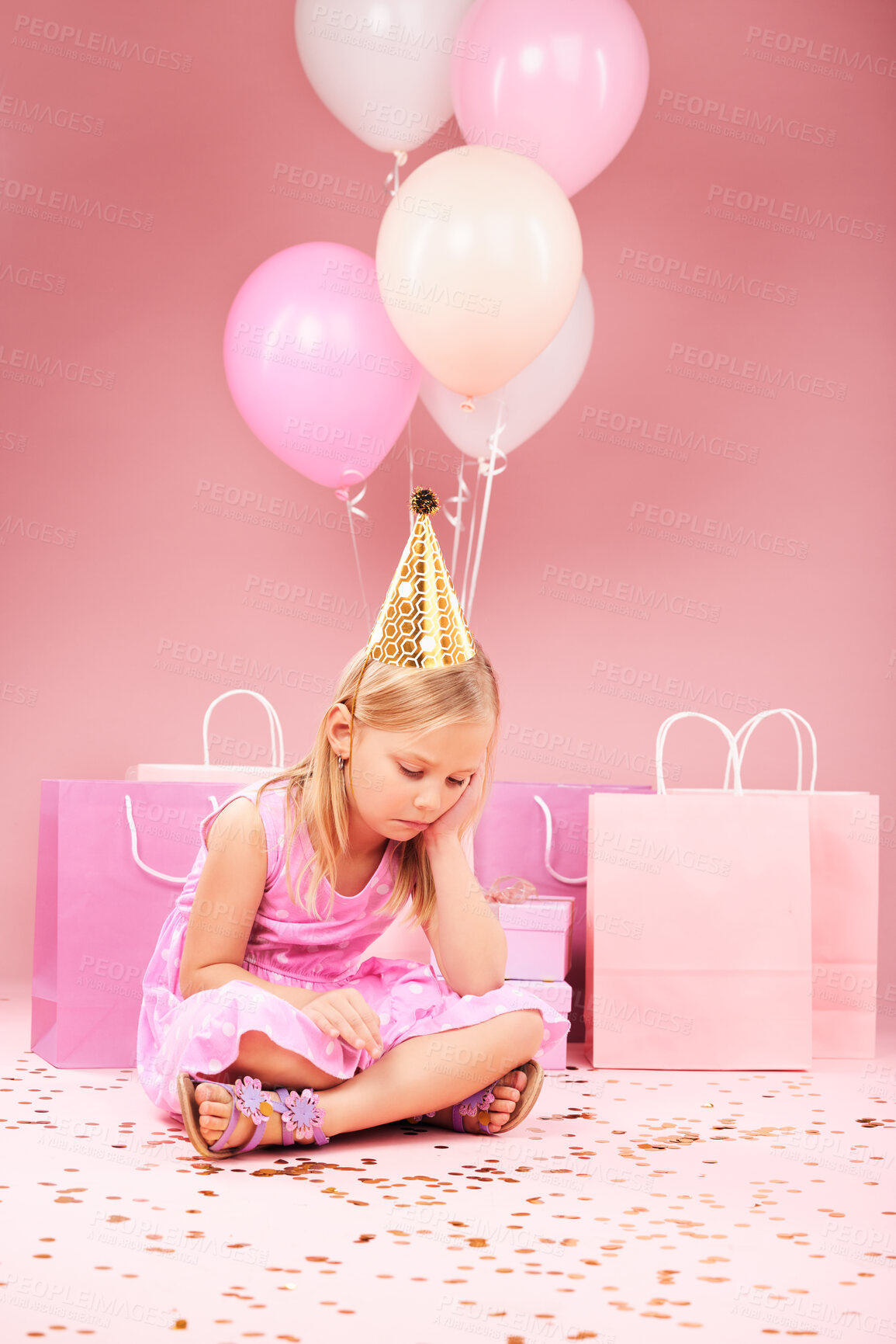 Buy stock photo Depression, sad birthday and girl on pink background for party, celebration and festive event in studio. Upset, emotion and unhappy, lonely and young child on floor with balloons, presents and gifts