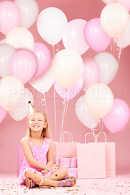 Buy stock photo Balloons, birthday and portrait of girl on pink background for party, celebration and special day. Happy, excited and young child sitting with presents, gift box and decoration for event in studio