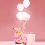 Balloons, birthday and girl on pink background for party, celebration and special day in studio. Happy, celebrate and young child sitting with presents, gift box and decoration for festive event