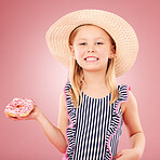 Happy, portrait and girl with a donut or child with sugar, dessert and sweet craving on pink background in studio. Face, smile and hungry kid with donuts on holiday, vacation or weekend diet 