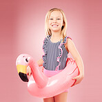 Girl child, summer and swimsuit with floater, flamingo and happiness with vacation isolated on pink background. Swimwear, fun and animal toys, happy kid in portrait and playful with holiday in studio