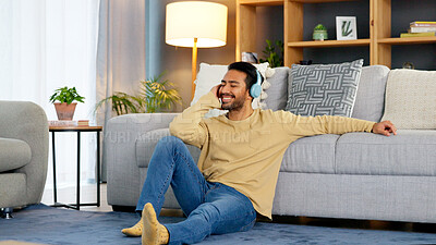 Buy stock photo Man, relax on living room floor and headphone, listening to music with audio streaming, happiness and tech at home. Chill at the weekend, wellness and podcast with sound, connectivity and radio