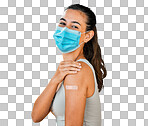 Mixed race covid vaccinated woman showing plaster on arm, wearing surgical face mask. Portrait of hispanic woman isolated against yellow studio background with copyspace. Protected with corona vaccine