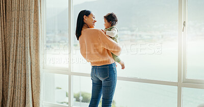 Care, happy and a mother with a baby in a house and looking at the view from a window. Smile, hug and a young mom holding a child for playing, bonding or love together in the morning as family