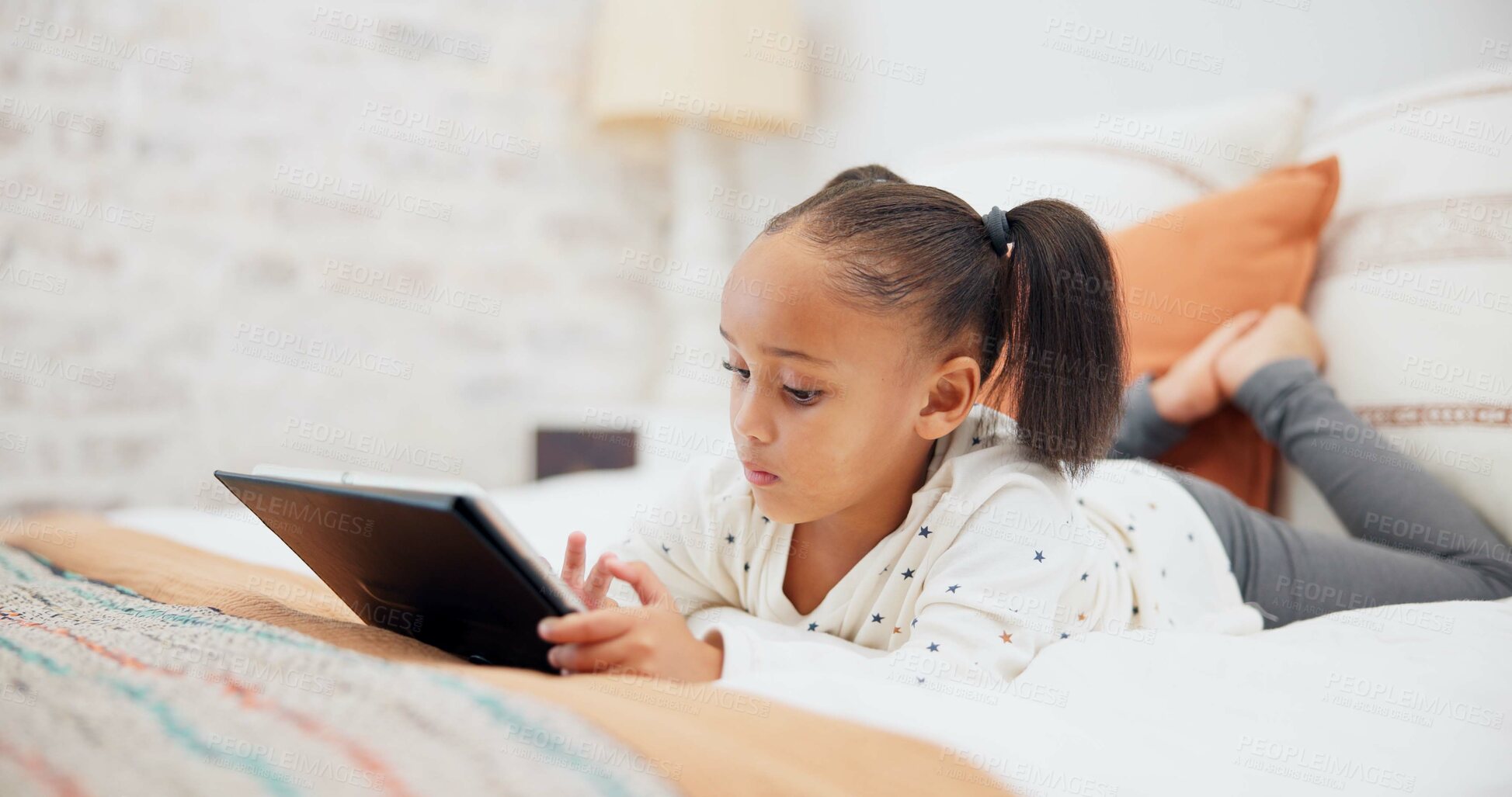 Buy stock photo Digital tablet, relax and child on the bed playing an online game or watching a video on the internet. Technology, rest and young girl kid networking on social media or mobile app in bedroom at home.