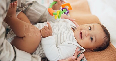 Baby child, rattle toys and bed with mother, playing or care in family home for learning with childhood development. Portrait, infant kid and excited for games, bonding and happy with mom in nursery
