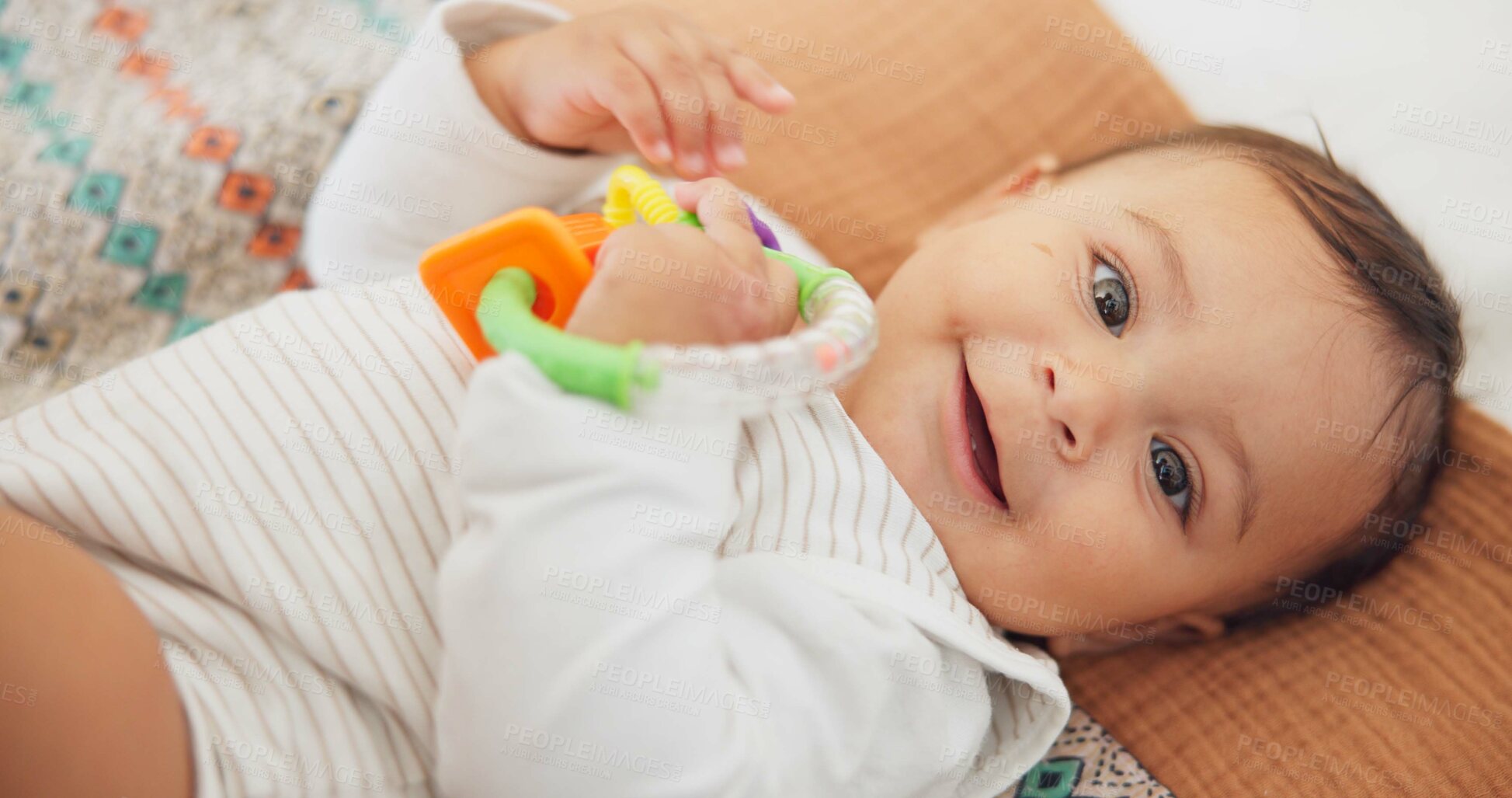 Buy stock photo Cute, playing and sweet baby with a toy on a blanket for child development, fun and entertainment. Happy, sweet and portrait of a playful infant child relaxing on a bed in his nursery or bedroom.