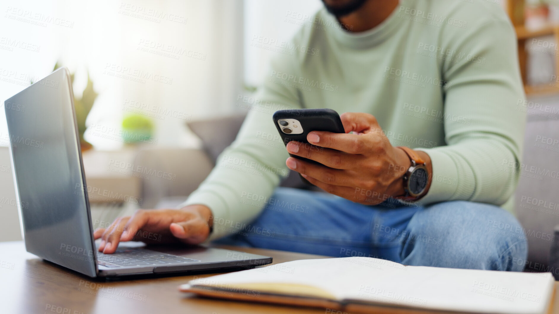 Buy stock photo Phone, laptop and man hands typing while doing research for a freelance project in his living room. Technology, keyboard and male freelancer working online with a computer and cellphone at his home.