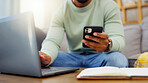 Phone, laptop and man hands typing while doing research for a freelance project in his living room. Technology, keyboard and male freelancer working online with a computer and cellphone at his home.