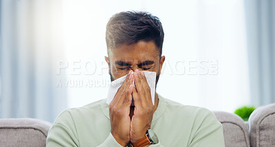 Buy stock photo Tissue, sneeze and Indian man blowing nose on a home living room sofa feeling sick and tired. Allergy problem, virus and toilet paper of a person on a house lounge couch with sinus infection and flu