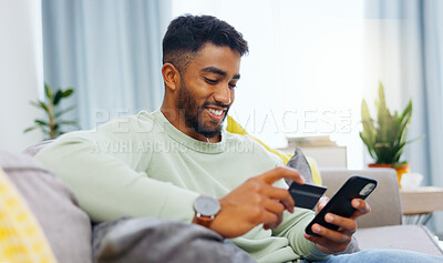 Credit card, finance and man with smartphone for online shopping in lounge at home. Indian, visa and money for e commerce transaction and search the internet for investment or product.