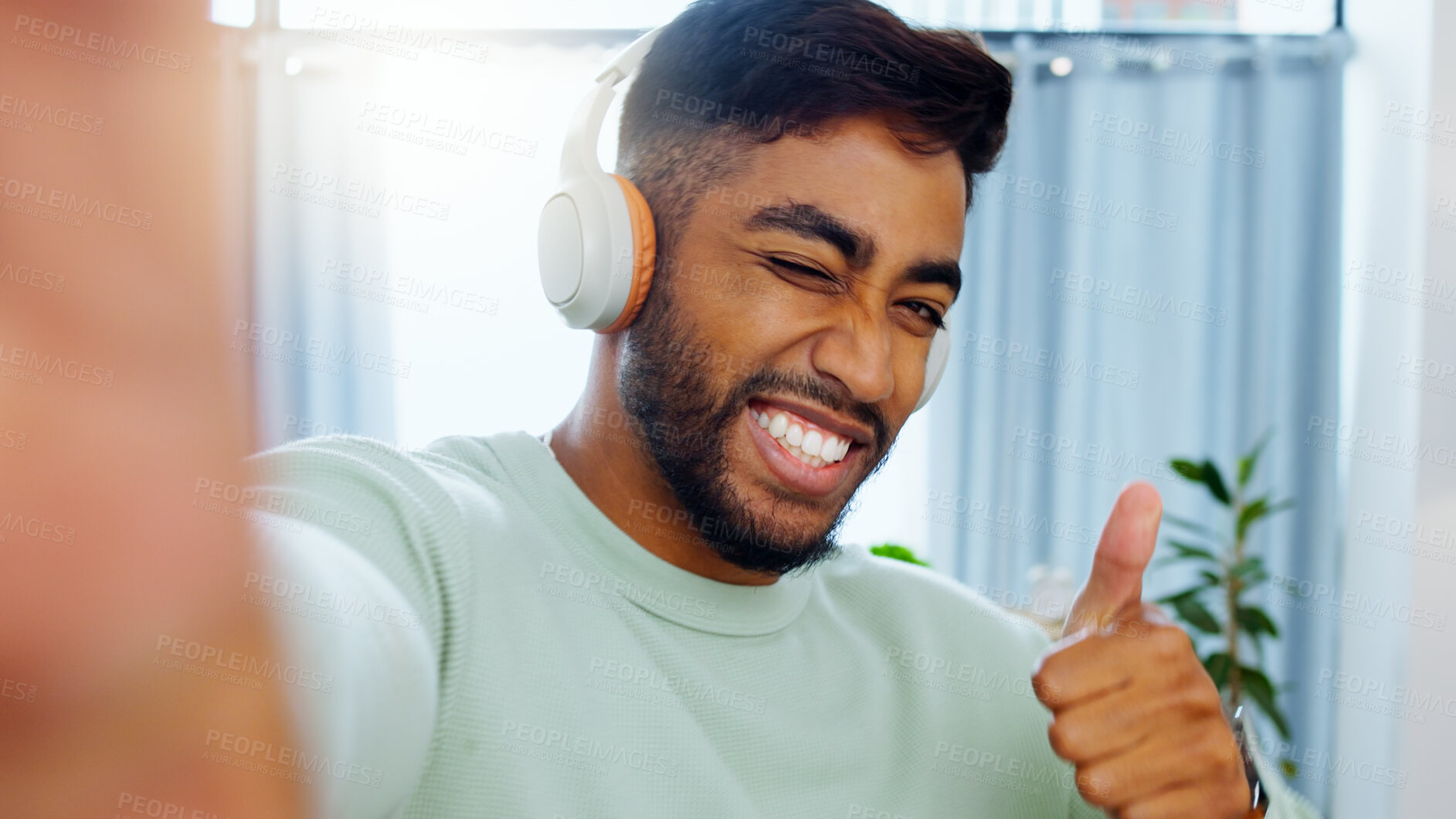 Buy stock photo Selfie, man and smiling thumbs up emoji headphones for music playlist streaming and cheerful mood in home. Wellness peace sign, audio and happy male ready to dance photograph with smile wink