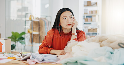 Woman or fashion designer thinking of ideas in manufacturing studio, inspiration or planning clothes production. Asian person contemplating creative or thoughtful strategy in textile, tailor business