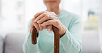 Hands, walking stick and elderly woman with walking stick on a sofa for balance, support and mobility. Walk, aid and old female at senior care facility with disability, dementia or chronic arthritis