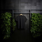 Black t-shirt mockup with copyspace on dark background with plants on hanger, front view