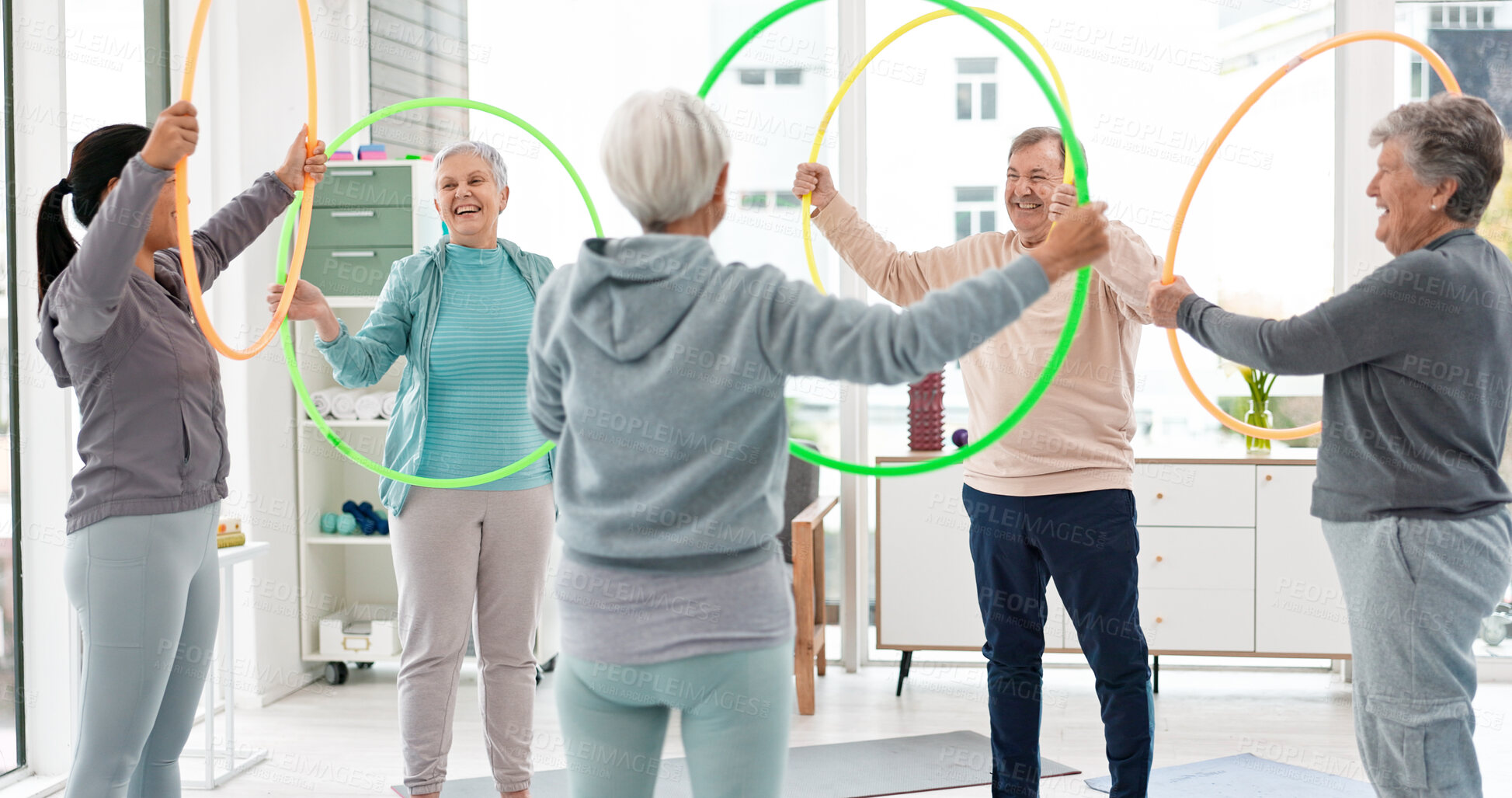 Buy stock photo Fitness, senior and people with hula hoop at the gym for training, workout and health in retirement. Happy, together and a group of elderly friends with a coach and gear for an exercise class