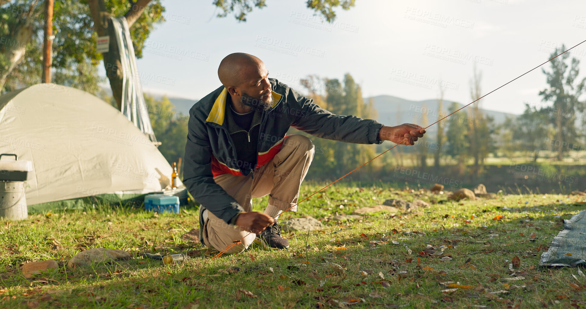 Buy stock photo Camping, tent in ground and black man setup in nature for shelter on outdoor holiday, vacation and adventure, Campsite, travel and male person with hammer for gear in woods, forest and countryside