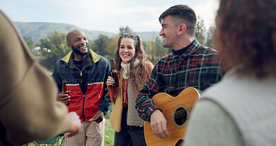 Singing, camping or happy friends with guitar dancing together in nature, woods or park on vacation. Men, women or fun people with beer or drinks by bonfire or campfire for music in forest on holiday