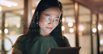 Woman, tablet and reading in night at office, focus or happy for social media app, chat or email. Asian web expert, digital marketing and working on strategy, tech business or social network in Tokyo