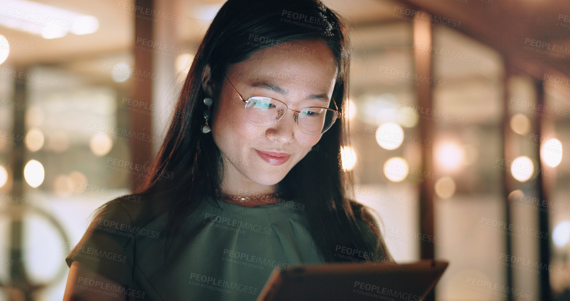 Buy stock photo Woman, tablet and reading in night at office, focus or happy for social media app, chat or email. Asian web expert, digital marketing and working on strategy, tech business or social network in Tokyo