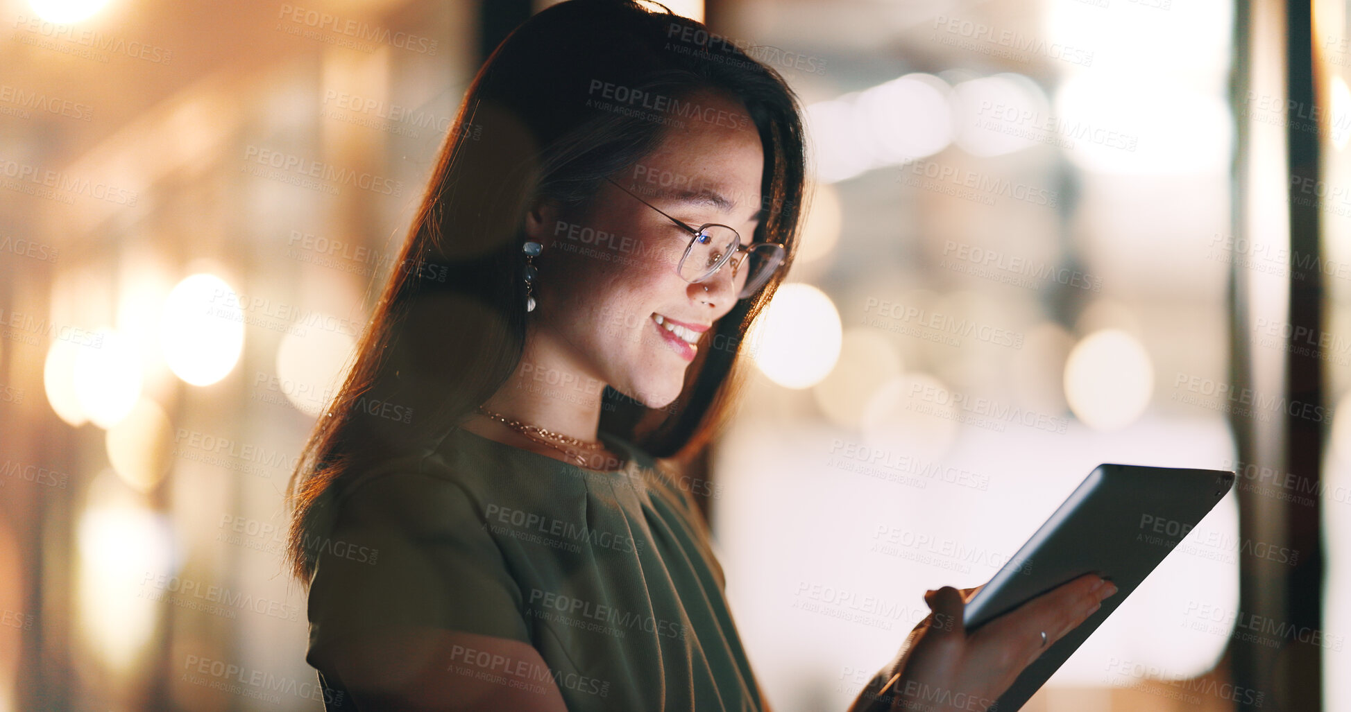 Buy stock photo Asian woman, tablet and typing in night office while working on project deadline. Digital tech, touchscreen and happy business woman working late in dark workplace, researching and writing email.