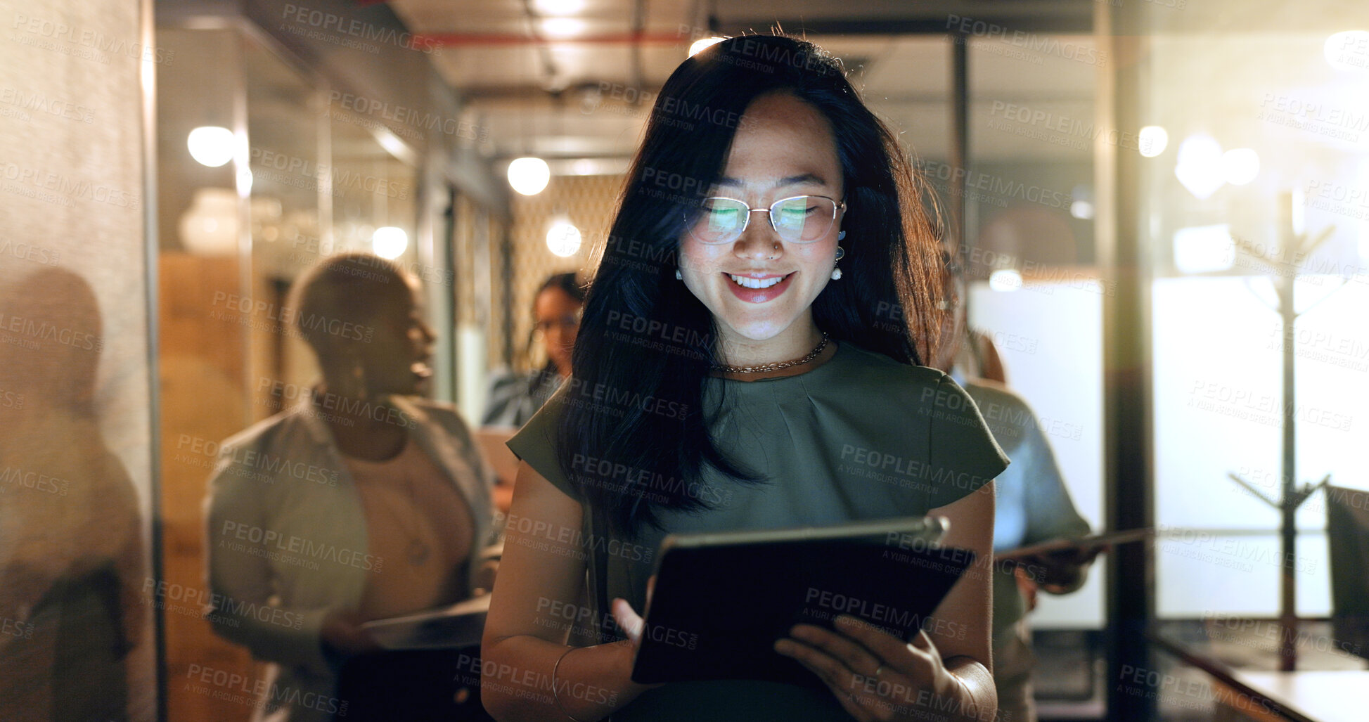 Buy stock photo Night, tablet and business people walking in office after finishing work task. Tech, overtime and Asian woman with group of friends going home after working late on sales project in dark workplace.