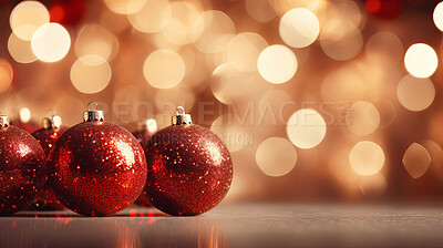 Shiny red christmas baubel decorations on table with bokeh copyspace