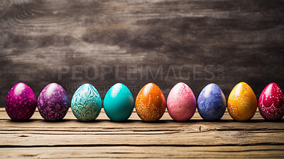 Row of colorful easter eggs on wooden table with copyspace. Chocolate candy in studio