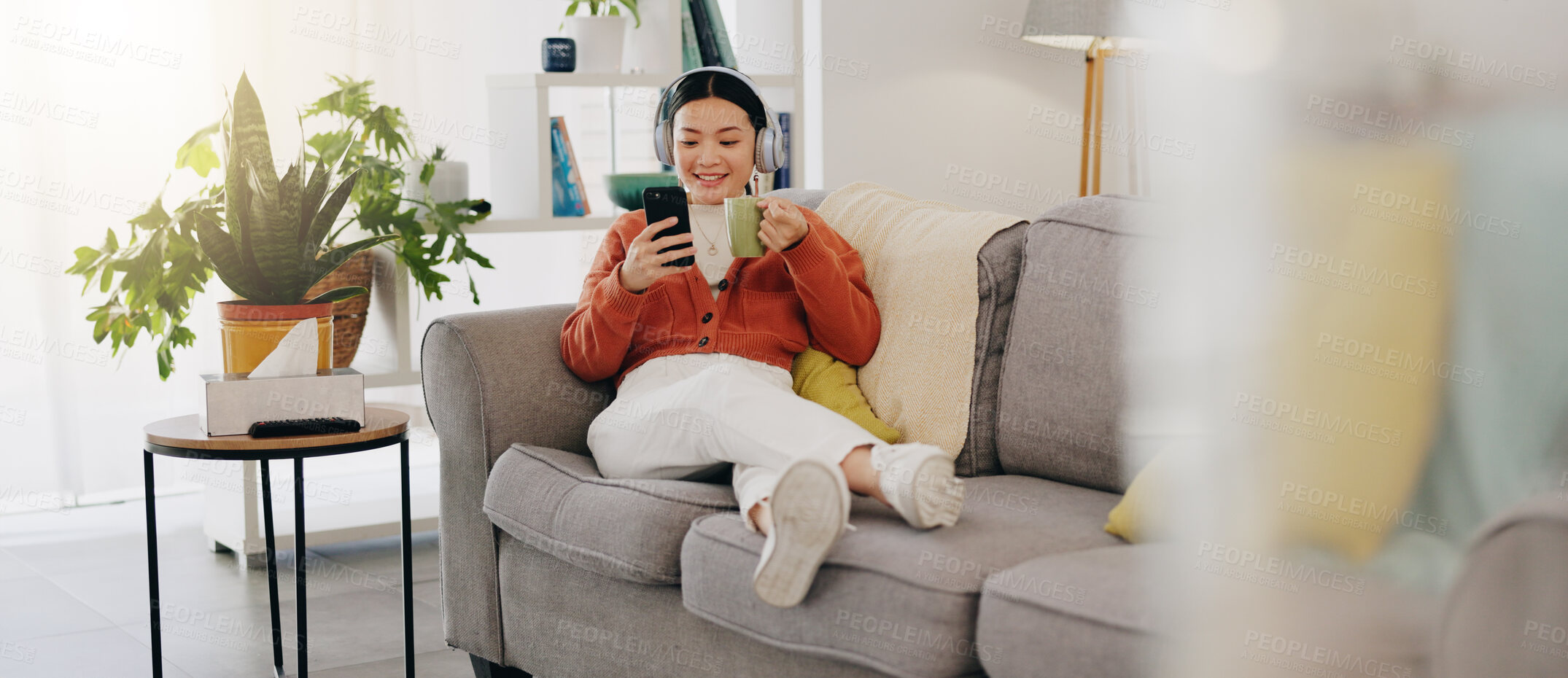 Buy stock photo Asian woman, phone or music headphones on relax sofa in house or Japanese home living room. Smile,enjoy or happy student with mobile technology for podcast, dance radio or audio playlist app in comfort