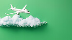 Airplane on green copyspace background with clouds. Sustainable travel, zero emissions travel concept