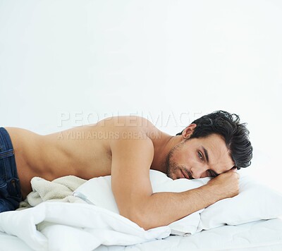 Buy stock photo Thinking, relax and topless with a sexy man on a bed, lying in studio on a white background. Tattoo, idea and shirtless with a handsome young male model posing in a bedroom for sensuality or desire