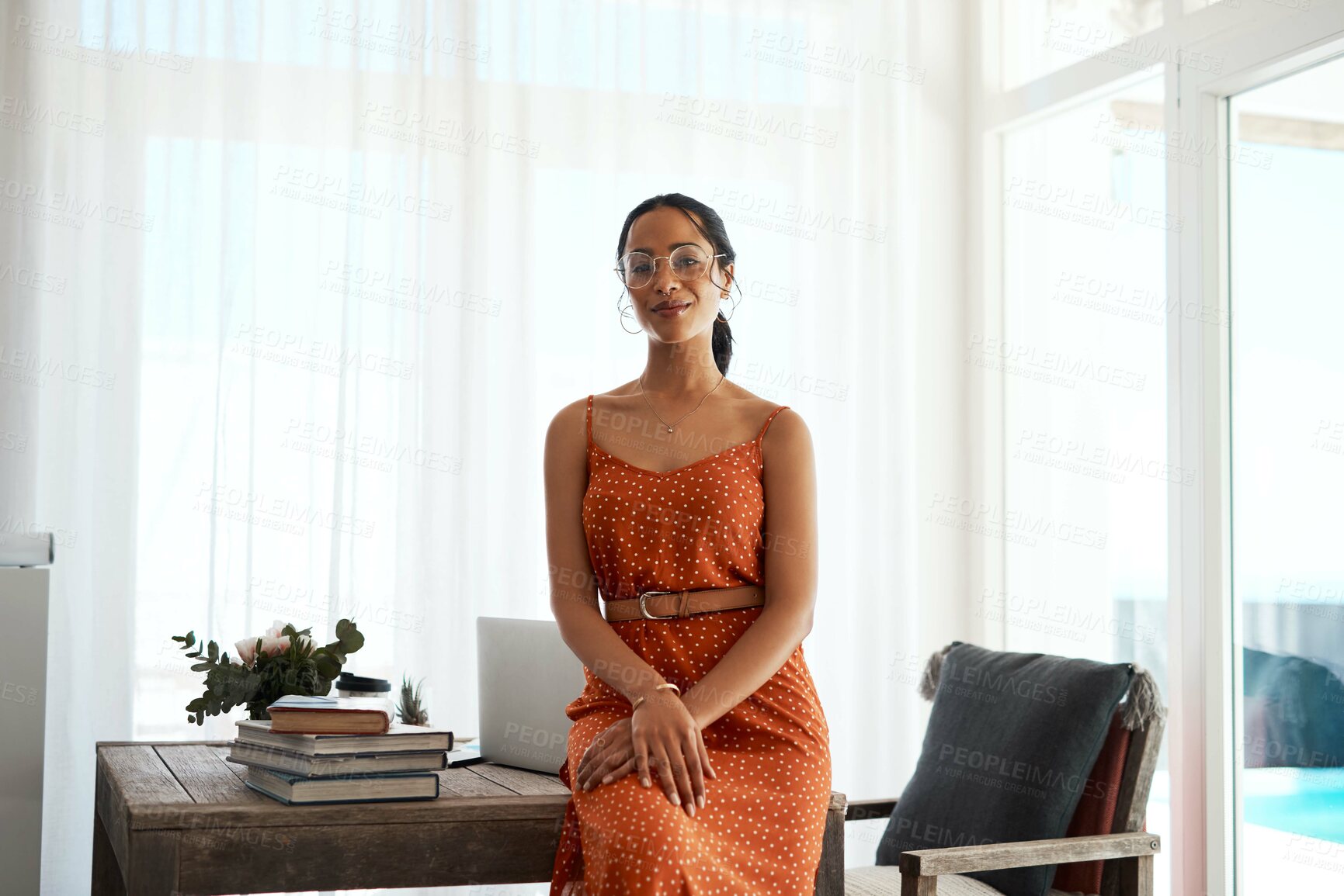 Buy stock photo Cropped portrait of an attractive young businesswoman sitting on her desk in her home office during a day off