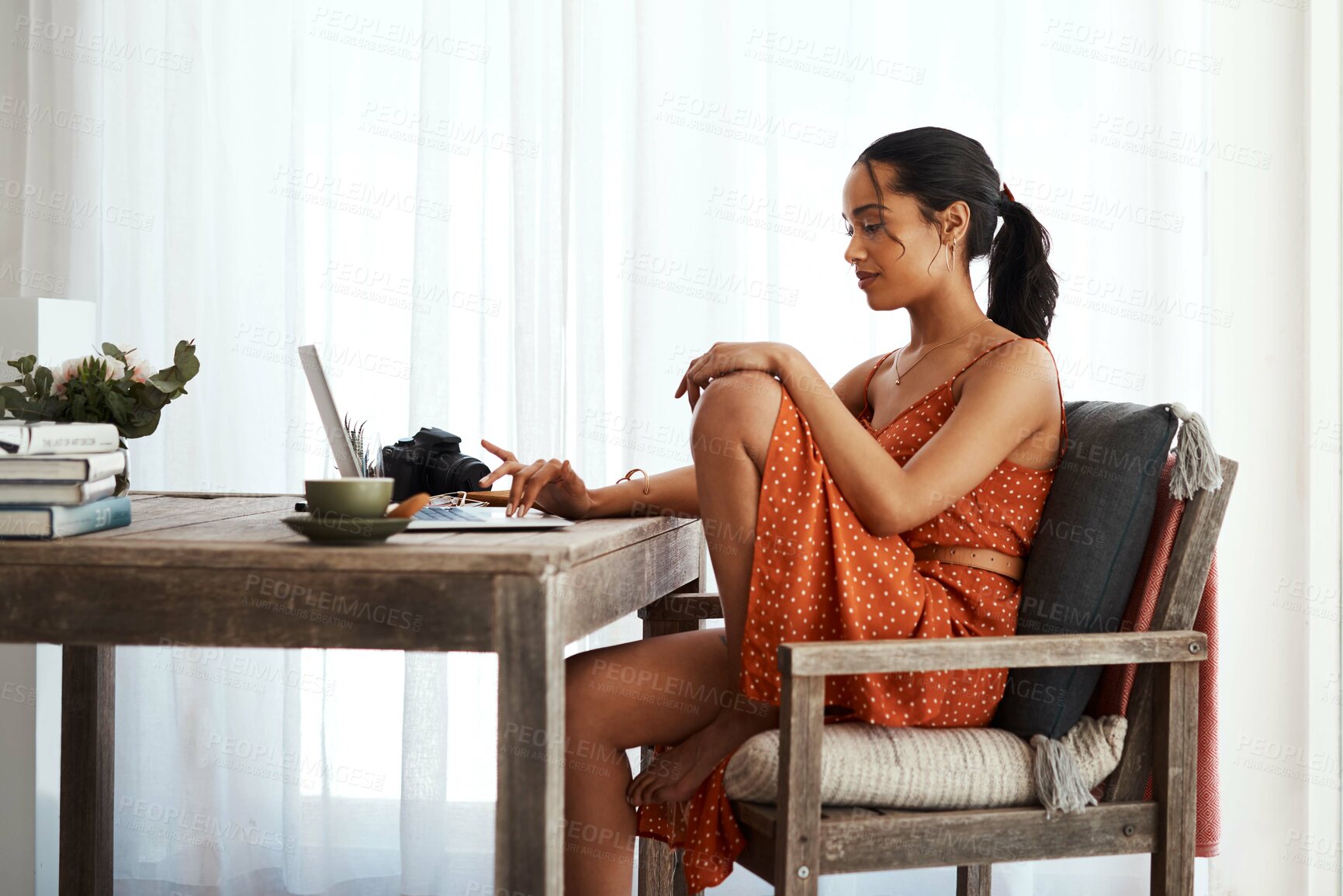 Buy stock photo Cropped shot of an attractive young businesswoman sitting in her home office and using her laptop