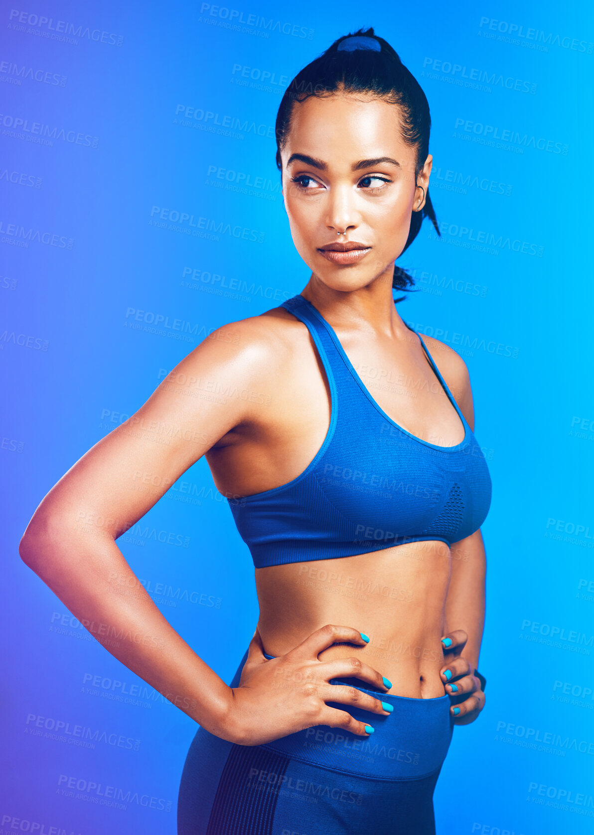 Buy stock photo Studio shot of an attractive young sportswoman posing against a blue background