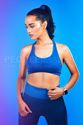 Buy stock photo Studio shot of an attractive young sportswoman posing against a blue background