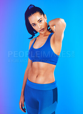 Buy stock photo Studio portrait of an attractive young sportswoman posing against a blue background