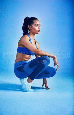 Buy stock photo Full length shot of an attractive young sportswoman posing in studio against a blue background