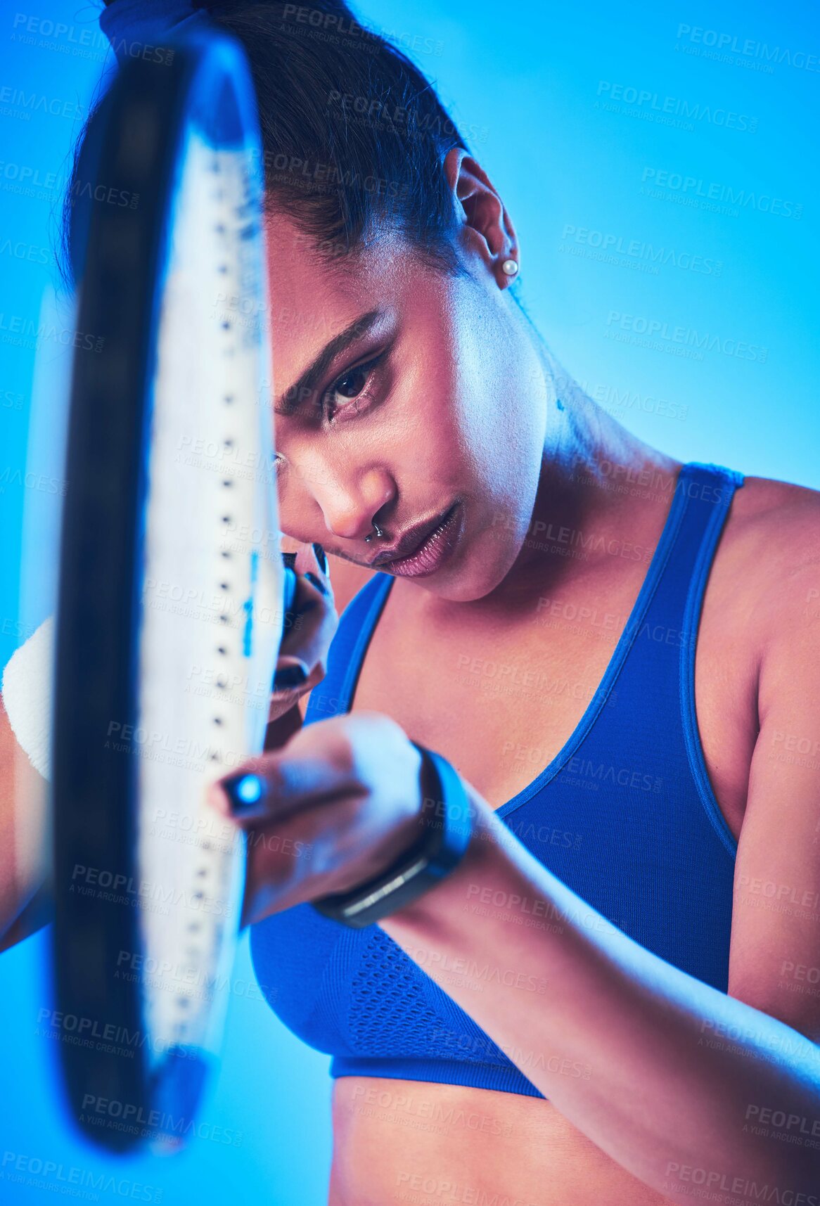 Buy stock photo Cropped shot of an attractive young female tennis player posing against a blue background