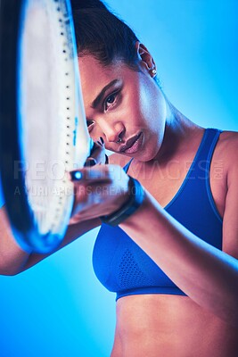 Buy stock photo Cropped shot of an attractive young female tennis player posing against a blue background