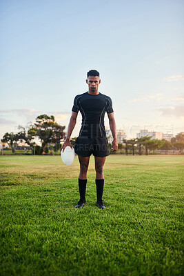 Buy stock photo Full length portrait of a handsome young sportsman standing alone and holding a rugby ball before an early morning practice