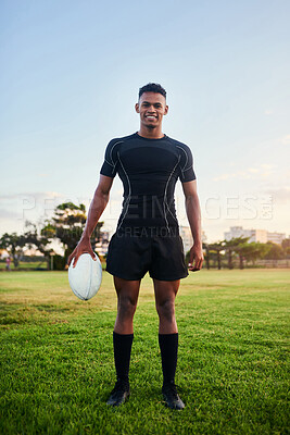 Buy stock photo Full length portrait of a handsome young sportsman standing alone and holding a rugby ball before an early morning practice
