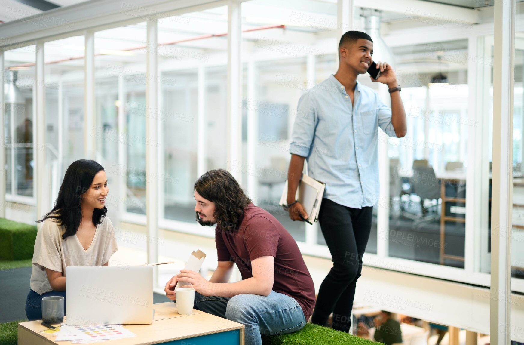 Buy stock photo Shot of two businesspeople having a discussion in an office with their colleague walking in the background