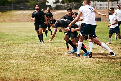 Buy stock photo Shot of a group of young men playing a game of rugby