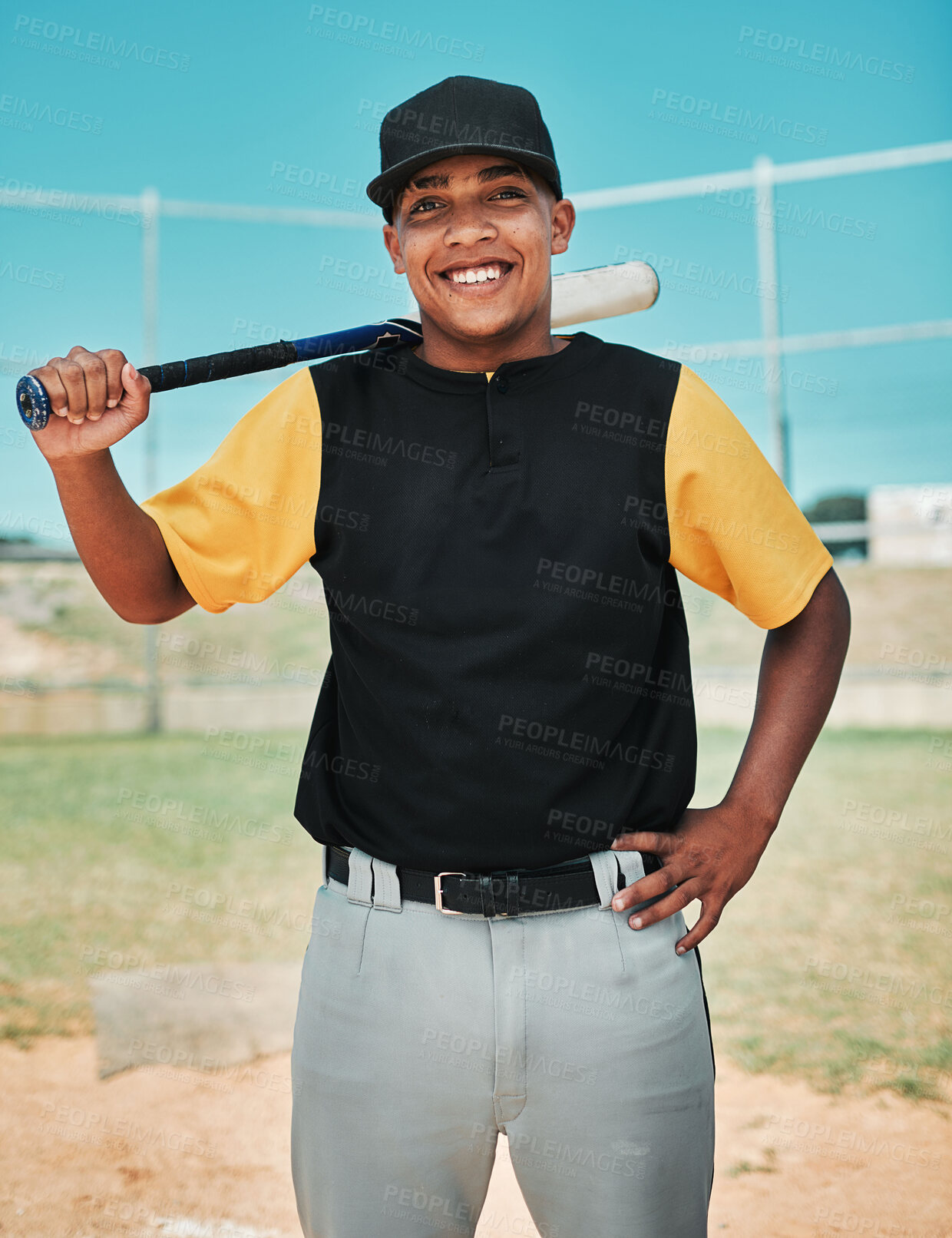 Buy stock photo Shot of a young baseball player holding a baseball bat while posing outside on the pitch