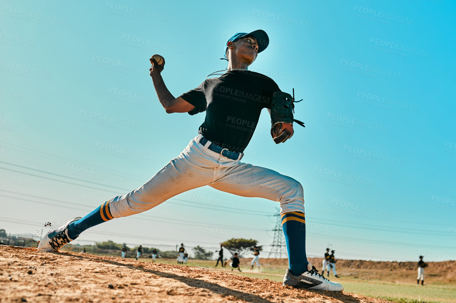 Buy stock photo Shot of a young baseball player pitching the ball during a game outdoors