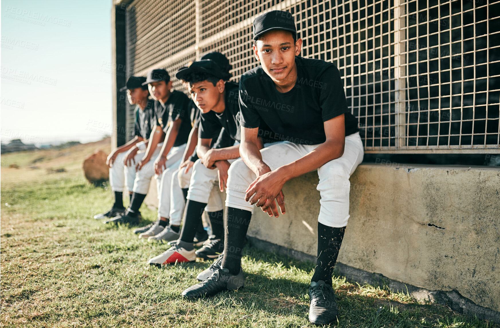 Buy stock photo Shot of a group of baseball players sitting together on a field