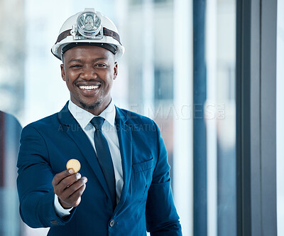 Buy stock photo Shot of a young businessman holding a bitcoin in a modern office