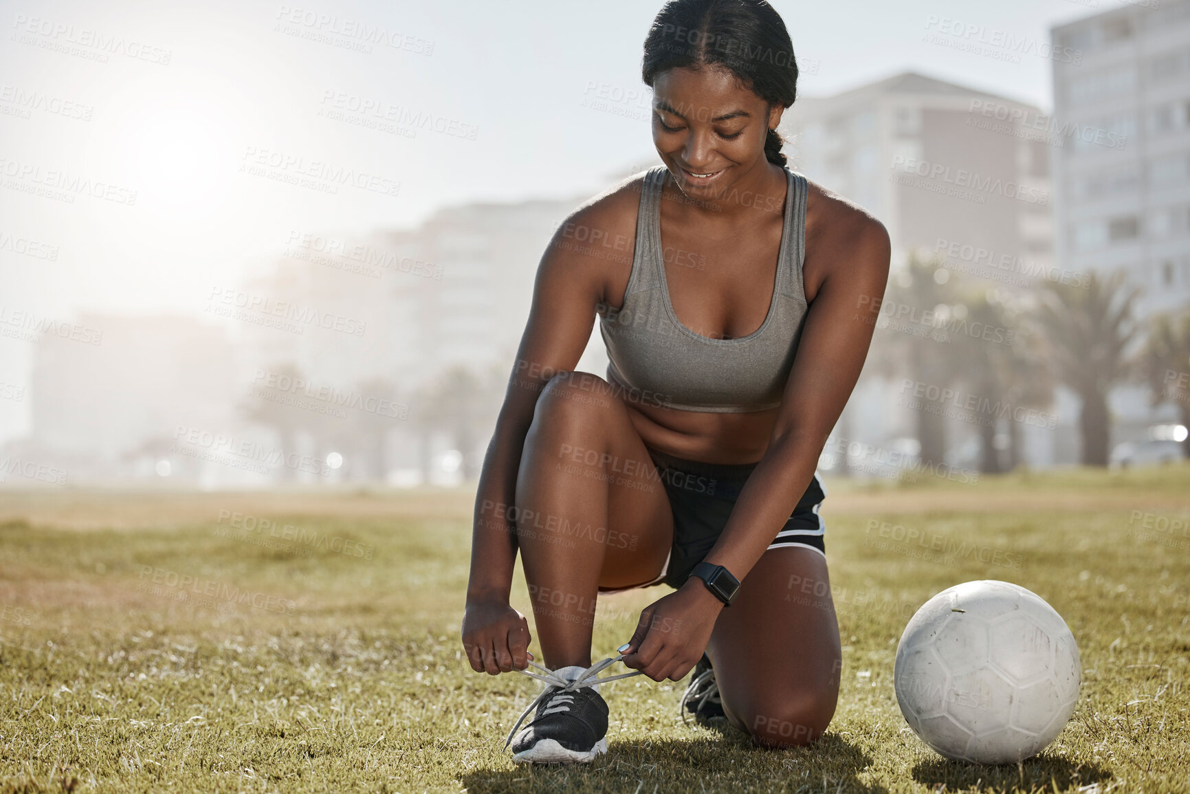 Buy stock photo Soccer, girl and black woman with shoes to start playing a football game for cardio exercise, workout and training. Sports, fitness and healthy athlete exercising ties boots on grass in Sao Paulo