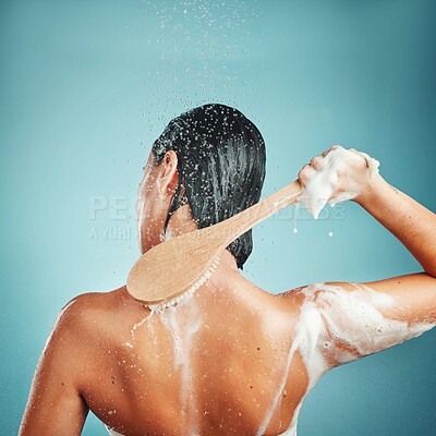 Skincare, hair and shower by woman in studio for wellness, cleaning and hygiene on blue background mockup. Water splash, brush and back of girl model in beauty splash, water and cleaning in bathroom
